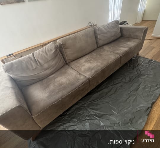 ספה חומה על רצפת עץ עם כיסוי מגן